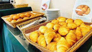 Ett buffébord med korgar fulla av croissanter och frallor.