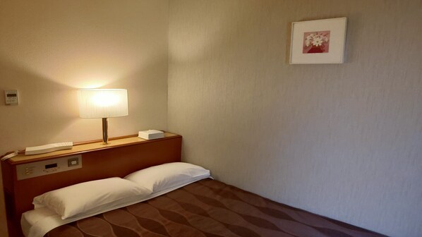 A hotel room with a bed, a bedside lamp, a telephone, a control panel, and a framed picture on the wall. - Center Hotel Narita 1 (Narita)