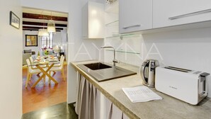 A modern kitchen with a stainless steel sink, a Bosch toaster, and a glass-fronted cabinet. - La Caravelle 1 bedroom apartment VRBO (Nice)