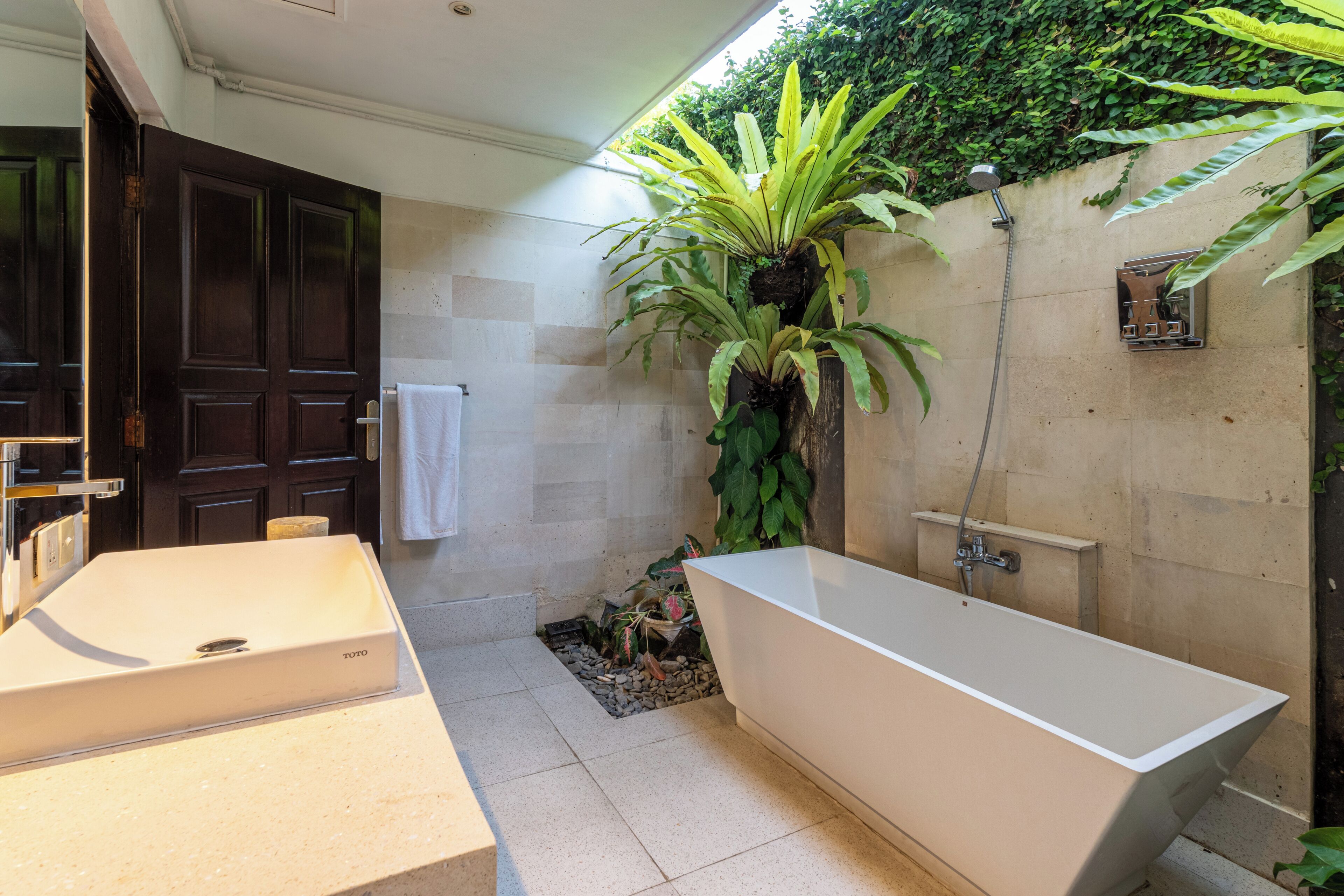 A bathroom with a bathtub, two sinks, and a door.
