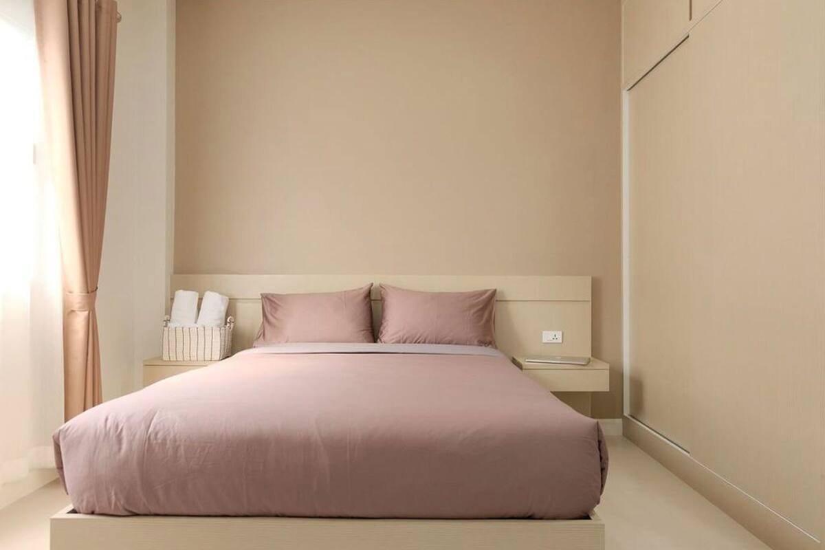 Une chambre à coucher avec un grand lit, des tables de chevet et une commode.