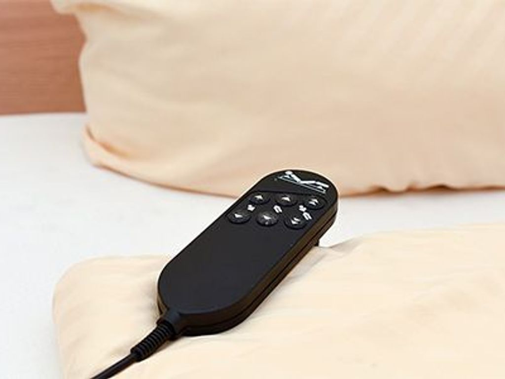 Une télécommande sur un lit.