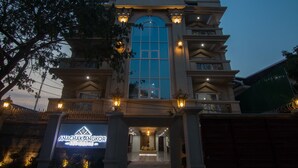 A building with a large arched window and a sign reading "Anachak Angkor". - Anachak Angkor Suite (Siem Reap)