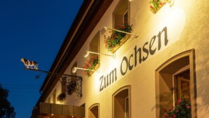 A building with the sign "Zum Ochsen" and flower boxes on the windows. - Gasthof Hotel zum Ochsen (Berghülen)