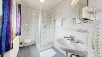 A bathroom with a shower, toilet, and sink.