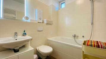 Ein Badezimmer mit Waschbecken, Toilette und Badewanne.