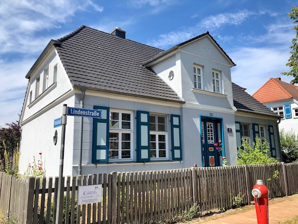 A two-story building with a sign for 'Lindenstraße' and a 'Christl' sign in front.