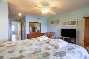A bedroom with a bed, a ceiling fan, a TV, and a dresser. - Riverfront condo w Open & Screened-In Porches with Water & Marsh Views and Community Pool (Folly Beach)