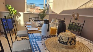 A dining table set with plates, cutlery, a coffee pot, a jug of orange juice, and a woven basket with "Read & Relax" on it. - RIAD L'EMPIRE in the heart of the MEDINA (Marrakech)