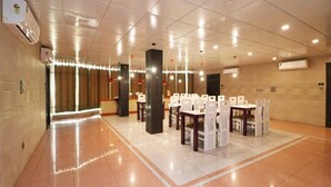 A spacious lobby with a tiled floor, multiple seating areas, and air conditioning units. - Ace Prime Hotel (Greater Noida)