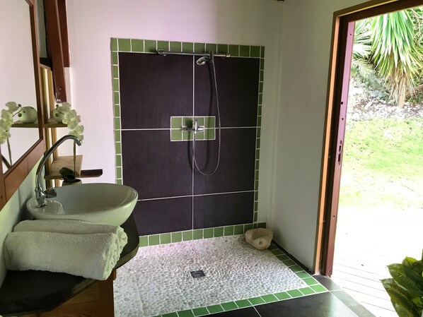 A bathroom with a sink, mirror, and shower area. - Wooden villa with private pool in a tropical garden 3 minutes from the beach (Sainte-Anne)
