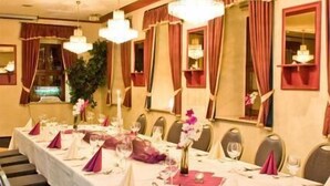 Une longue table de banquet, dressée pour un événement formel, avec des chaises alignées de part et d’autre.