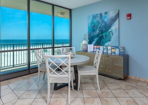 Enjoy stunning ocean views from the large window in this room, featuring a round table, comfortable seating, and a beautiful painting.