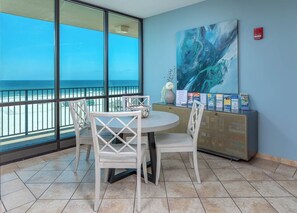 Enjoy stunning ocean views from the large window in this room, featuring a round table, comfortable seating, and a beautiful painting.