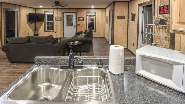 A kitchen with a double sink, a microwave, and a roll of paper towels. - Mid- Lake home, perfect for a group w/ lots of boat and truck parking (Scottsboro)