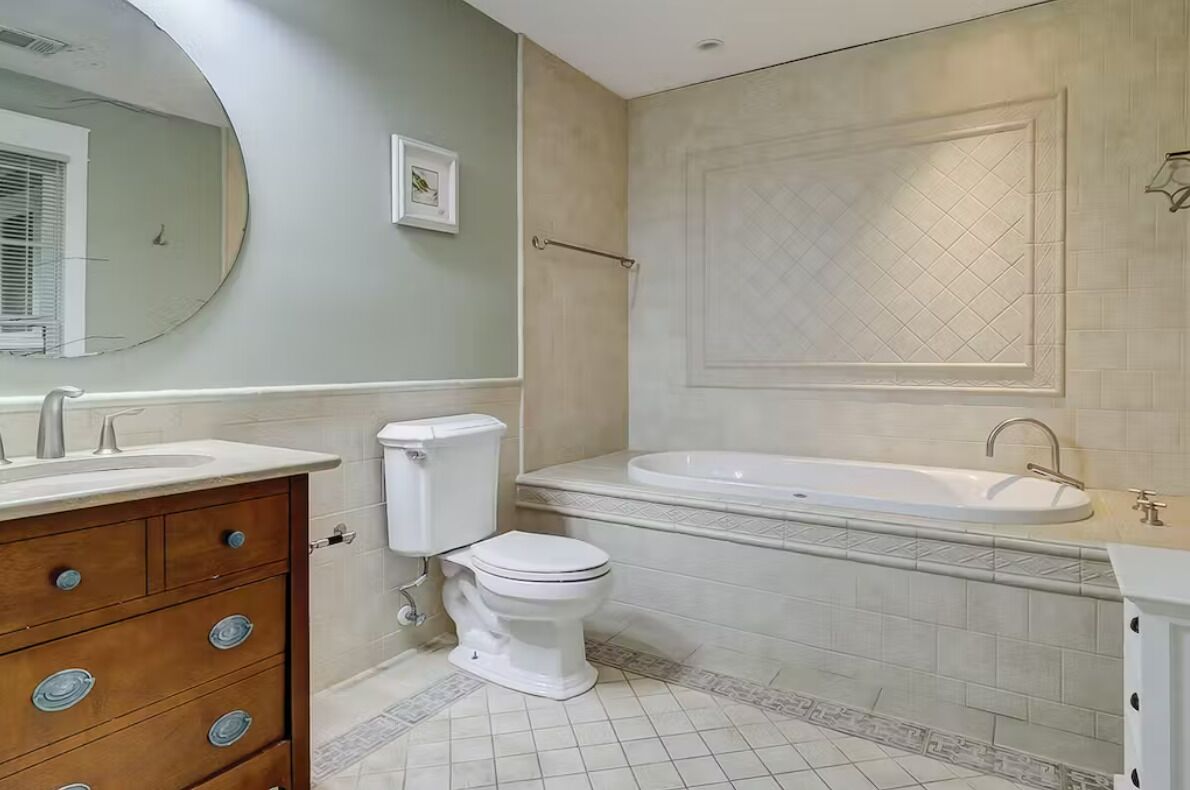 Une salle de bain avec des toilettes, un lavabo et une baignoire.