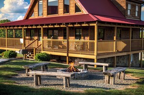 A wooden cabin with a red roof, a covered deck, and a fire pit. - Big Sky, Breathtaking Mtn View, Free Attraction Tickets, Pool Table, Hot Tub!!! (Sevierville)