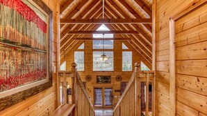 A wooden interior with a staircase leading to a door, large windows, and a ceiling fan. - Big Sky, Breathtaking Mtn View, Free Attraction Tickets, Pool Table, Hot Tub!!! (Sevierville)