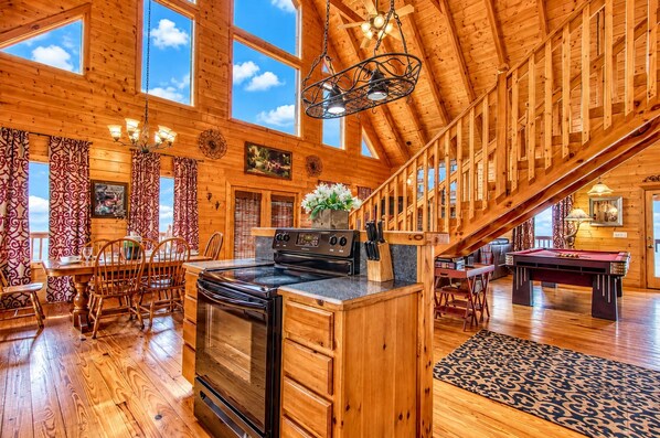 A spacious wooden cabin with a dining area, kitchen, and pool table. - Big Sky, Breathtaking Mtn View, Free Attraction Tickets, Pool Table, Hot Tub!!! (Sevierville)