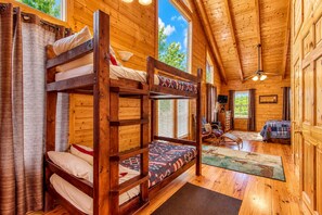 A cabin with bunk beds, a fireplace, a TV, and a view of the outdoors. - Big Sky, Breathtaking Mtn View, Free Attraction Tickets, Pool Table, Hot Tub!!! (Sevierville)