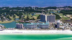 A coastal resort with multiple high-rise buildings, a beachfront, and surrounding greenery.
