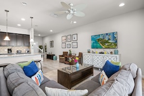A modern living room with a sofa, coffee table, and dining area.