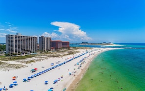 A beach resort with a long row of beach umbrellas, a sandy beach, and a clear blue ocean. - Phoenix East II 2125 - 3BR Condo on the Beach! (Orange Beach)