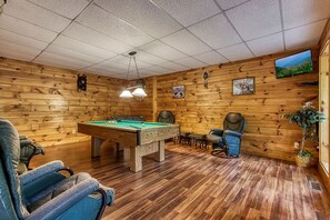 A pool table in a room with wooden walls and a ceiling with square tiles. - Awesome Honey Bear, “Cozy Cabin Retreat in the Smokies – Comfort & Fun for All”! (Sevierville)