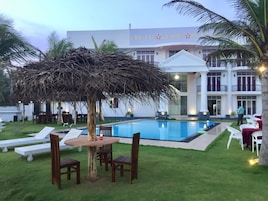 Un resort con piscina, mobiliario exterior y un edificio con un letrero que dice 'CRYSTAL RESORT'.