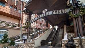 An entrance to a hotel with a sign reading "Beaver Creek" and an escalator leading up.