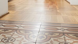 A hallway with patterned floor tiles, a red chair, and a vase on a table. - Hotel la Scala (Florence)
