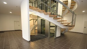 A modern interior with a spiral staircase, a glass door entrance, and a tiled floor. - Käptn Brass App 8 - Käpt`n Brass App. 8 (Dierhagen)