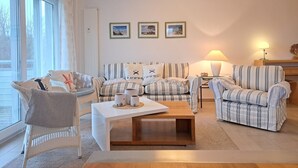 A living room with a sofa set, a coffee table, and a lamp. - Käptn Brass App 8 - Käpt`n Brass App. 8 (Dierhagen)