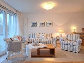 A living room with a sofa set, a coffee table, and a lamp. - Käptn Brass App 8 - Käpt`n Brass App. 8 (Dierhagen)