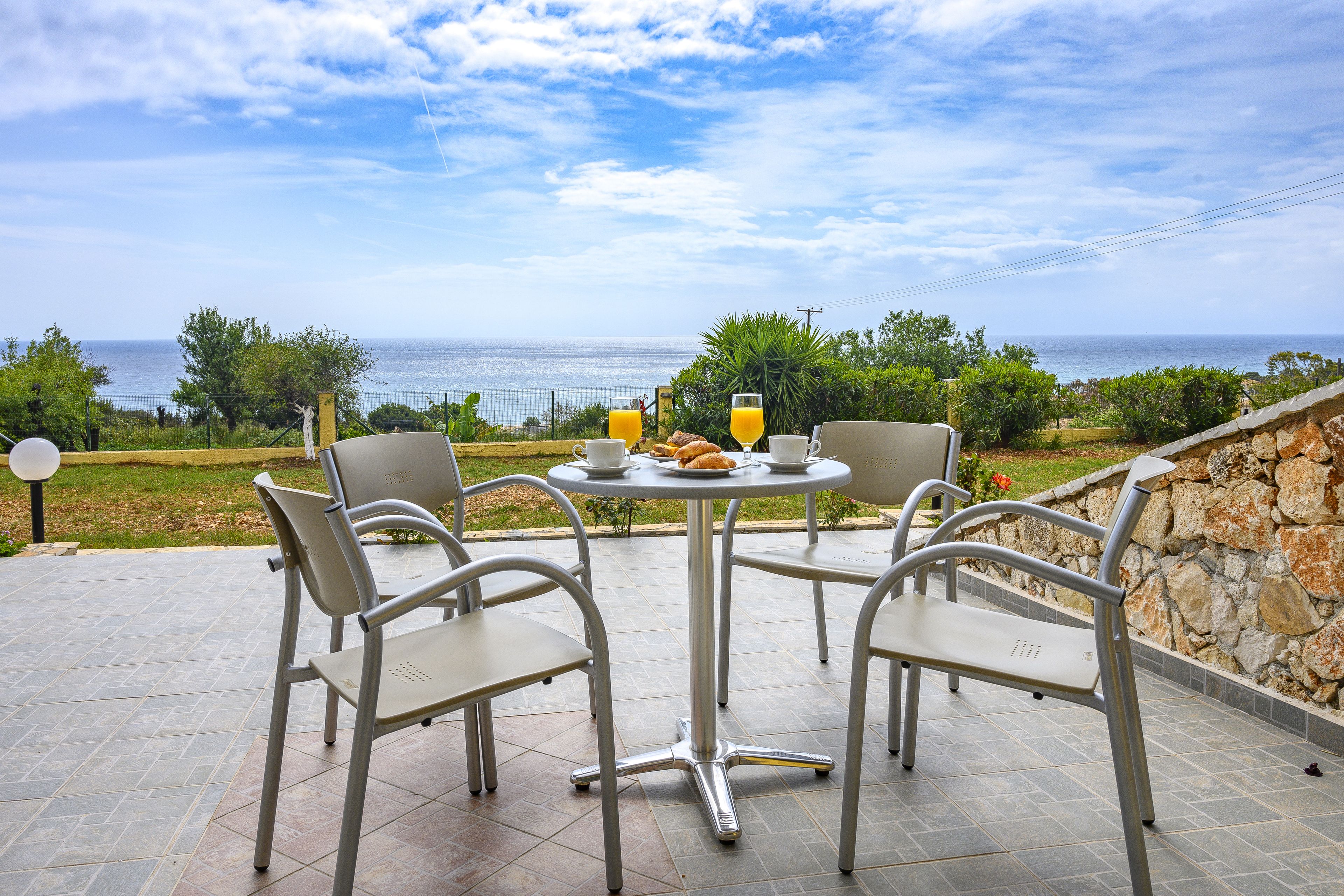 Una terraza con mesa y sillas con vista al mar.
