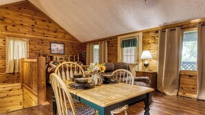 A cozy cabin interior with a wooden dining table, chairs, and a sofa. - Forever Yours, 2 Hot tubs, FREE Attraction tickets, WIFI, Near The Parkway!!! (Pigeon Forge)
