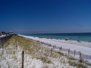 A beach with a wooden fence and beachgoers. - Emerald Gulf, Pool & Hot tub at your patio,-FREE BEACH ITEMS - pocket doors (Miramar Beach)
