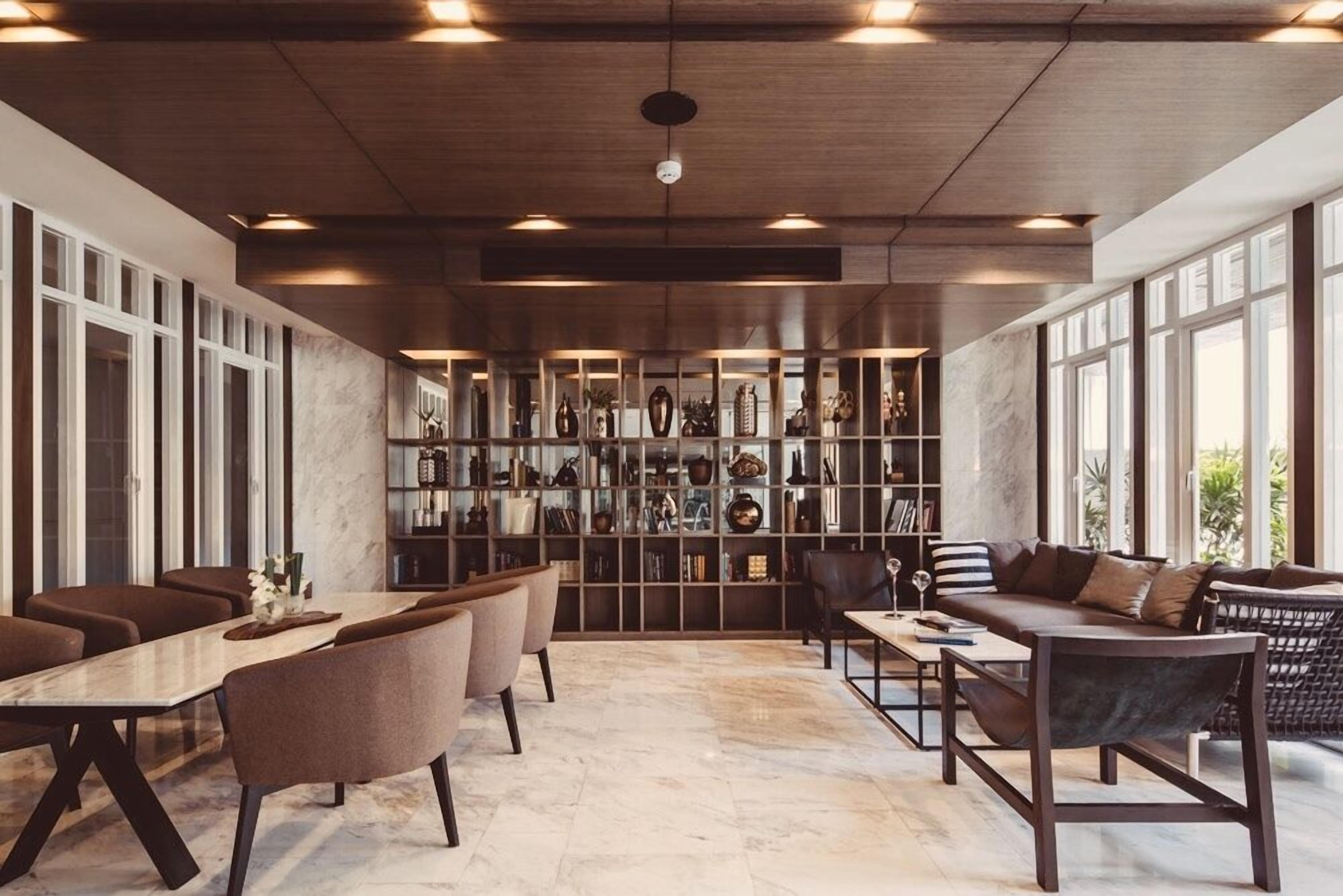 A modern interior with a dining area, seating, and a large bookshelf filled with decorative items.