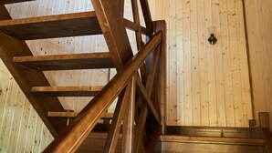 Eine Holztreppe mit Blick auf eine Holzwand und einer Lampe.