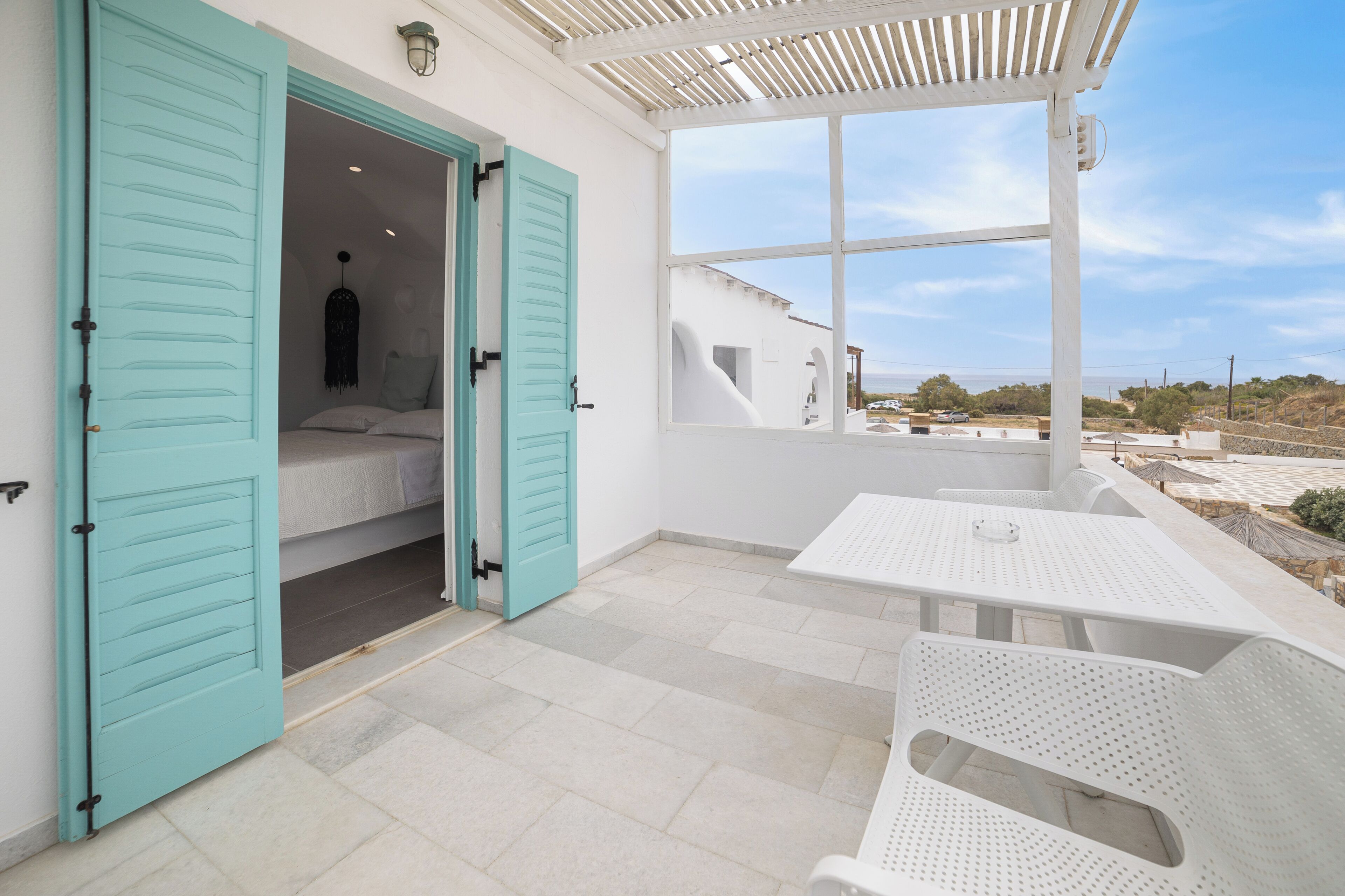 A room with a bed, a window, and a table with chairs.
