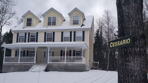Ett tvåvåningshus med en inglasad veranda och en skylt med texten ”Cessario”.