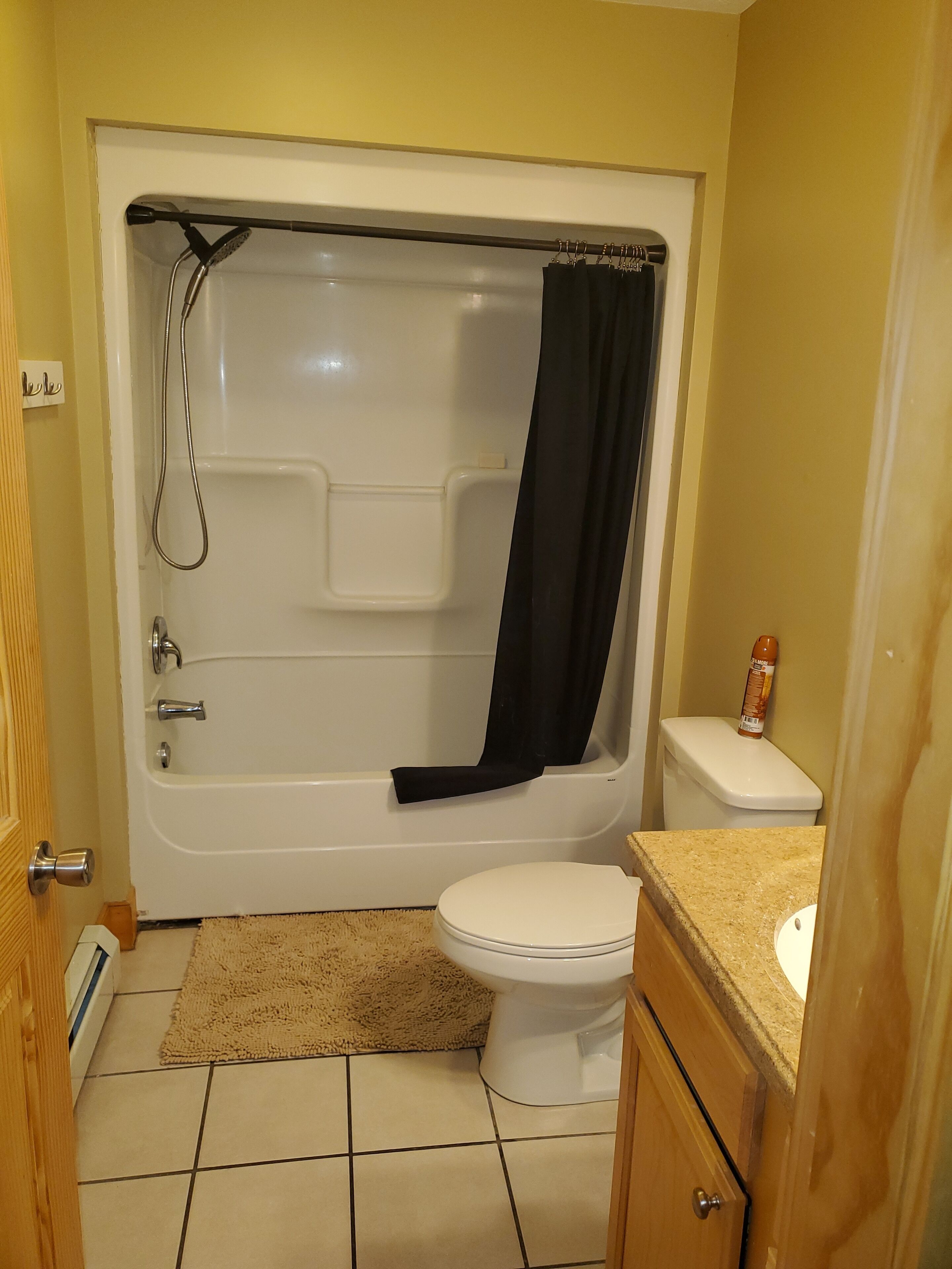 A bathroom with a bathtub, toilet, and sink.