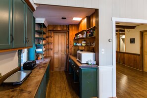 Una cocina con armarios de madera, microondas y fregadero.