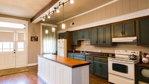 Une cuisine avec des meubles en bois, un îlot central blanc et un four encastré.