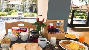 A breakfast setup with bread, butter, milk, coffee, and a fruit plate. - Tamara Resort Bangsary (Sattahip)