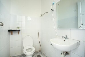 A bathroom with a white toilet, a sink, and a mirror.