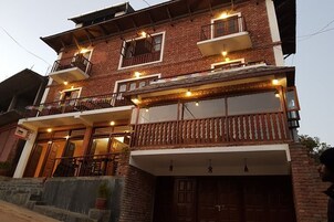 Un edificio de varios pisos con balcones, ventanas grandes y fachada de ladrillo.