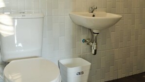 A bathroom with a toilet, sink, and mirror. - Kiangtan Houses (Pluak Daeng)