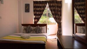 Un dormitorio con cama, almohadas, mesita de noche y cortinas.