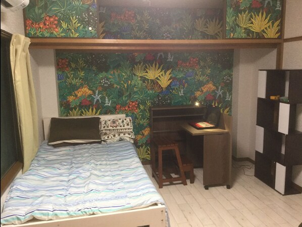 A bedroom with a bunk bed, a desk, and a bookshelf.